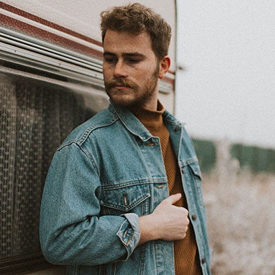 a male model wearing a blue denim jacket